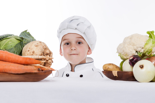 Один маленький хлопчик як шеф-кухар готує салат, готує з овочами
 - Фото, зображення
