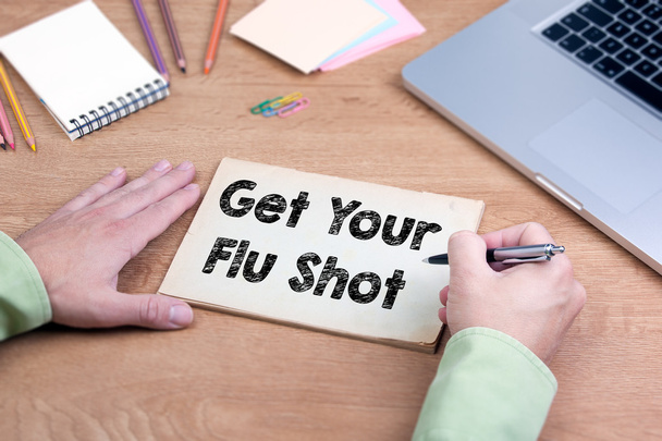 Scrivere a mano Get Your Flu Shot. Scrivania ufficio con computer portatile e st
 - Foto, immagini