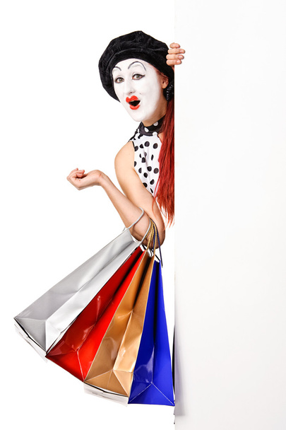 Jolie femme mime tenant panneau d'affichage vierge et sacs à provisions
 - Photo, image