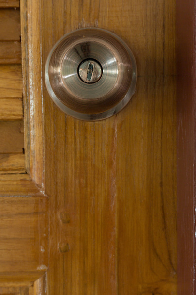 ajtó gomb és a fából készült ajtó kulcslyuk - Fotó, kép