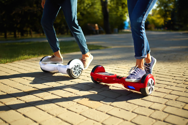 young man and woman riding on the Hoverboard in the park. content technologies. a new movement - Fotó, kép