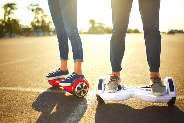 young man and woman riding on the Hoverboard in the park. content technologies. a new movement - Fotó, kép