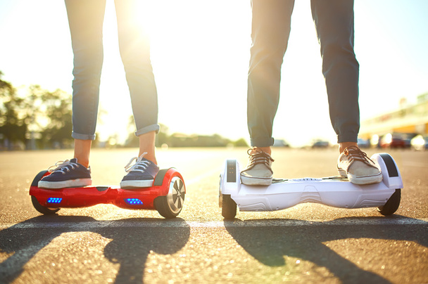 young man and woman riding on the Hoverboard in the park. content technologies. a new movement - Foto, imagen