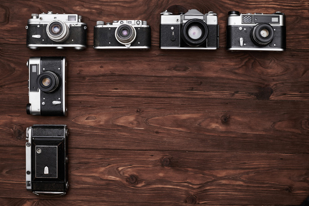 Oldtimer-Kameras liegen senkrecht im dunklen hölzernen Flachbereich - Foto, Bild