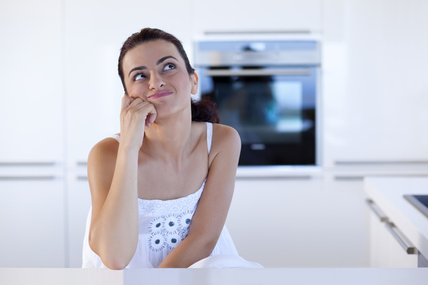 Προσωπογραφία γυναίκας χαρούμενος σκέψης στην κουζίνα counter - Φωτογραφία, εικόνα