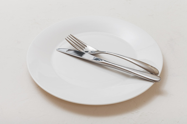 placa blanca con cuchillo paralelo, cuchara sobre blanco
 - Foto, Imagen