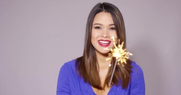 Beautiful woman holding a burning sparkler - Кадри, відео