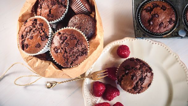 Chocolate muffins with red juicy raspberries  - Foto, afbeelding