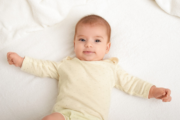 μωρό πορτραίτο βρίσκονται σε λευκή πετσέτα στο κρεβάτι, κίτρινο τονισμένο - Φωτογραφία, εικόνα
