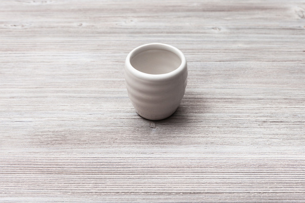 white cup for sake on gray brown wooden table - Φωτογραφία, εικόνα
