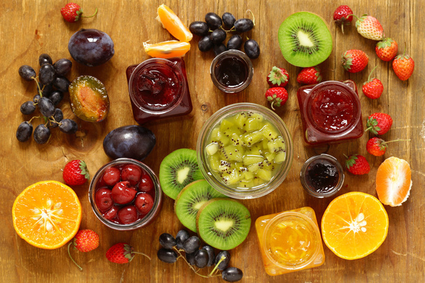 Surtido de bayas y mermeladas de frutas. Enlatado casero. Bayas y frutas frescas
 - Foto, Imagen