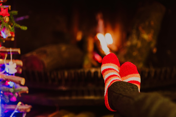 Woman feet in wool socks warming by fireplace - Fotoğraf, Görsel