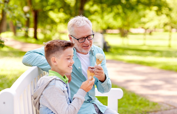 old man and boy eating ice cream at summer park - Foto, Bild