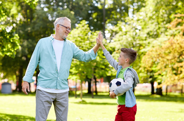 old man and boy with soccer ball making high five - Zdjęcie, obraz
