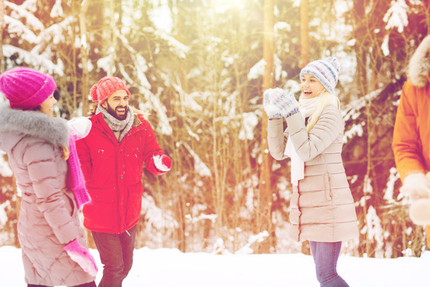 happy friends playing snowball in winter forest - Photo, image