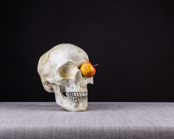 El cráneo oliendo y mirando con un ojo de manzana
  - Foto, Imagen