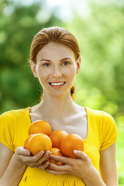Jeune femme en chemisier jaune aux oranges
 - Photo, image
