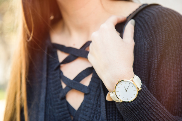 fall fashion details, young business woman holding her golden watch. graded in warm colors. - Photo, Image