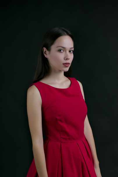 beautiful girl in a red dress on black background - Foto, immagini