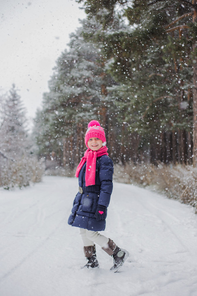 Snowing. Girl walks in the snow-covered forest in autumn day. - 写真・画像