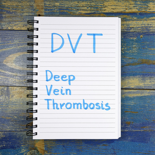 DVT- Thrombose veineuse profonde acronyme écrit dans un cahier sur fond en bois
 - Photo, image