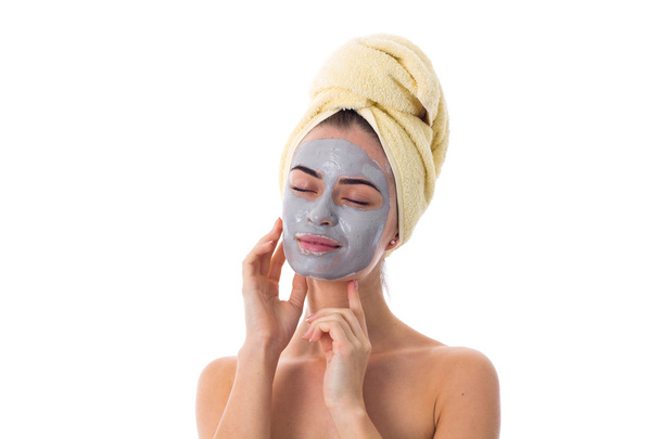 Mulher com toalha na cabeça e máscara cosmética no rosto
 - Foto, Imagem