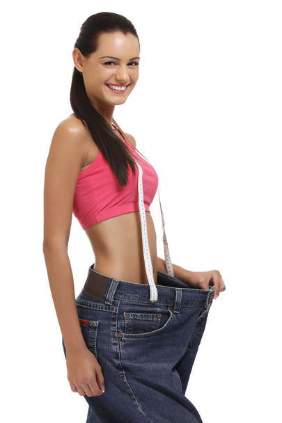 Weightloss concept - brunette woman showing slimming on white ba - Foto, imagen