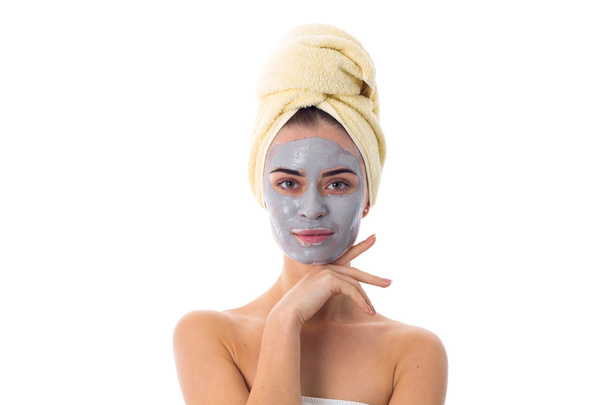 Mulher com toalha na cabeça e máscara cosmética no rosto
 - Foto, Imagem