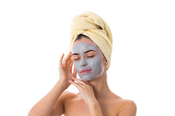 Γυναίκα με πετσέτα στο κεφάλι και καλλυντικά μάσκα στο πρόσωπό της - Φωτογραφία, εικόνα