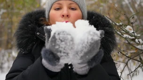κορίτσι φυσάει χιόνι με χέρια closeup στον slowmo - Πλάνα, βίντεο
