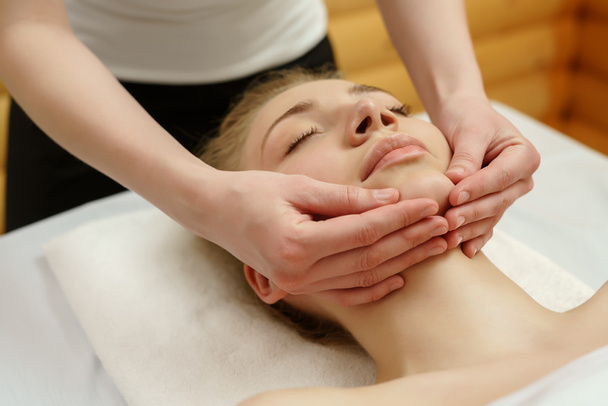 Spa. Massage therapist massaging clients chin - Photo, image