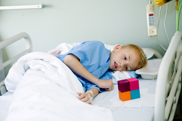 Sick boy in hospital bed looking at his toy - Fotografie, Obrázek