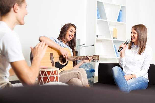 Friends enjoying playing guitar and singing together - Foto, imagen