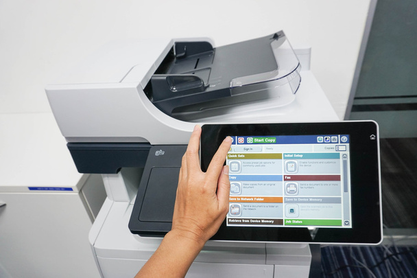 mujer utilice la pantalla táctil de la impresora para copiar documentos
 - Foto, imagen
