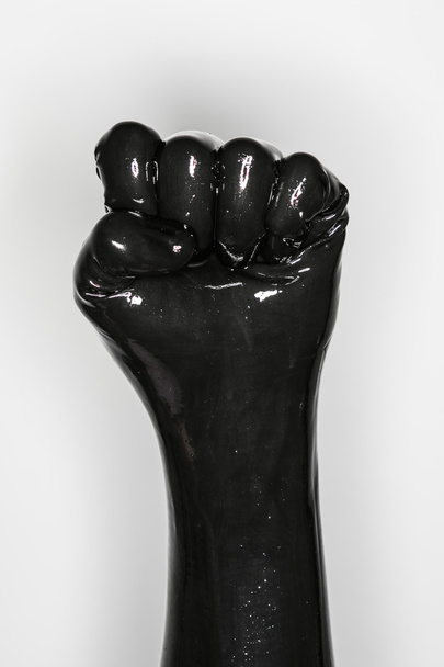 gebaar van een hand, het dragen van een zwarte latex handschoen: vuist - Foto, afbeelding
