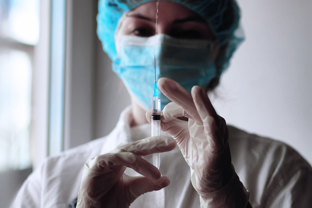 L'operatore sanitario inserisce il vaccino in una siringa - Foto, immagini