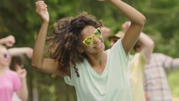 Šťastná dívka v sluneční brýle tanec, zvyšování rukou, baví, navíc slow-mo - Záběry, video