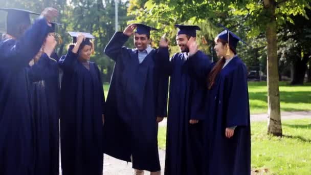 happy students throwing mortar boards up - Footage, Video