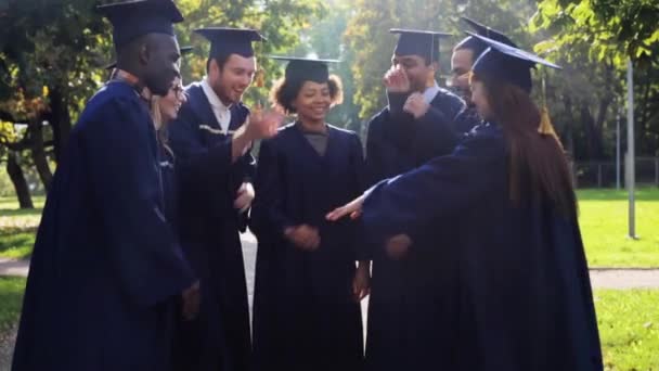 estudantes felizes em placas de argamassa com as mãos no topo
 - Filmagem, Vídeo