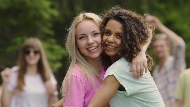 Jonge mooie vrouwen knuffelen, glimlachend op camera, groep jongeren feesten - Video