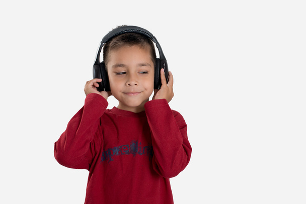 de jongen in oortelefoons luistert naar muziek - Foto, afbeelding