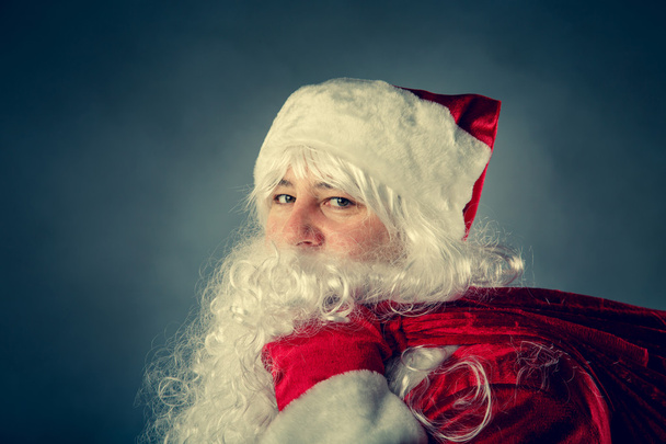 Санта-Клауса несе мішок з подарунками. - Фото, зображення