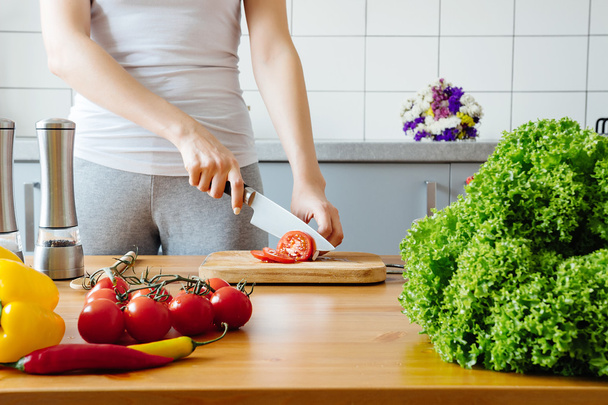 young woman cooking healthy meal in the kitchen - Foto, Bild