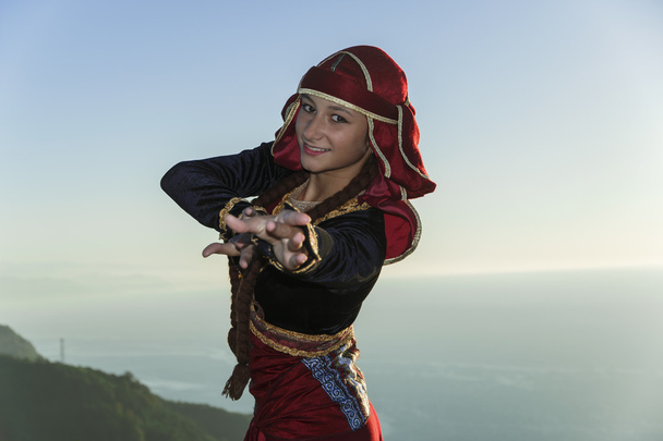 fiatal nő táncol a grúz nemzeti ruhák hegyek szabadban nyári napos - Fotó, kép