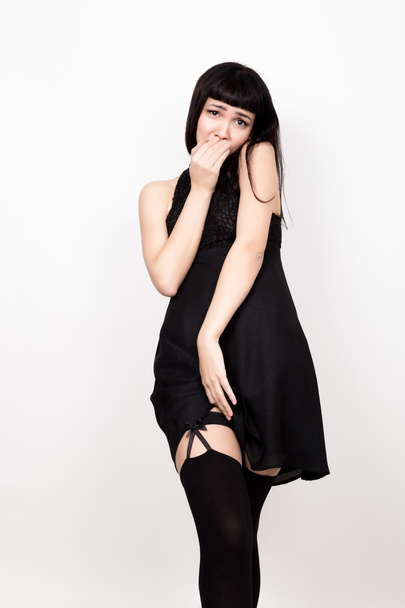 beautiful young woman in a short black dress and black stockings - Fotó, kép