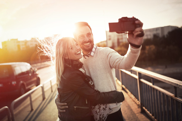 Happy couple taking selfies in city - Fotoğraf, Görsel