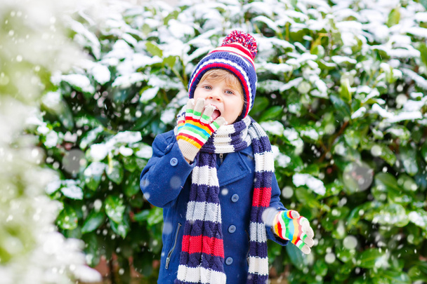 Ευτυχισμένο παιδί έχοντας διασκέδαση με το χιόνι το χειμώνα - Φωτογραφία, εικόνα