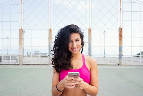 Sporty young woman texting on smartphone - Φωτογραφία, εικόνα