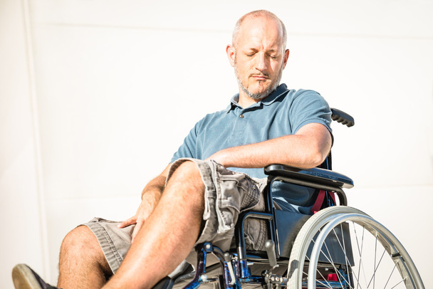 Niepełnosprawny mężczyzna z handicapem na wózku inwalidzkim w depresji moment - pojęcie niepełnosprawności z bezsilni unhelped osoba siedzi sama na wózku inwalidzkim - zagadnienia społeczne z nieprawidłowy facet na trudności - Zdjęcie, obraz