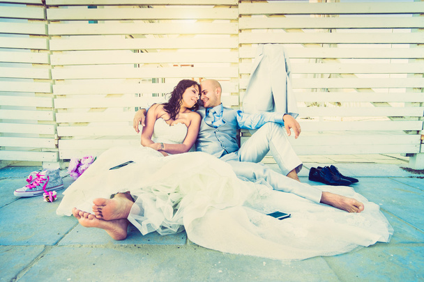 Young newlyweds having an emotional rest together after wedding ceremony - Life and love concept with lovely couple of groom and bride - Lower view point composition with soft lomo vignetted filter - Φωτογραφία, εικόνα